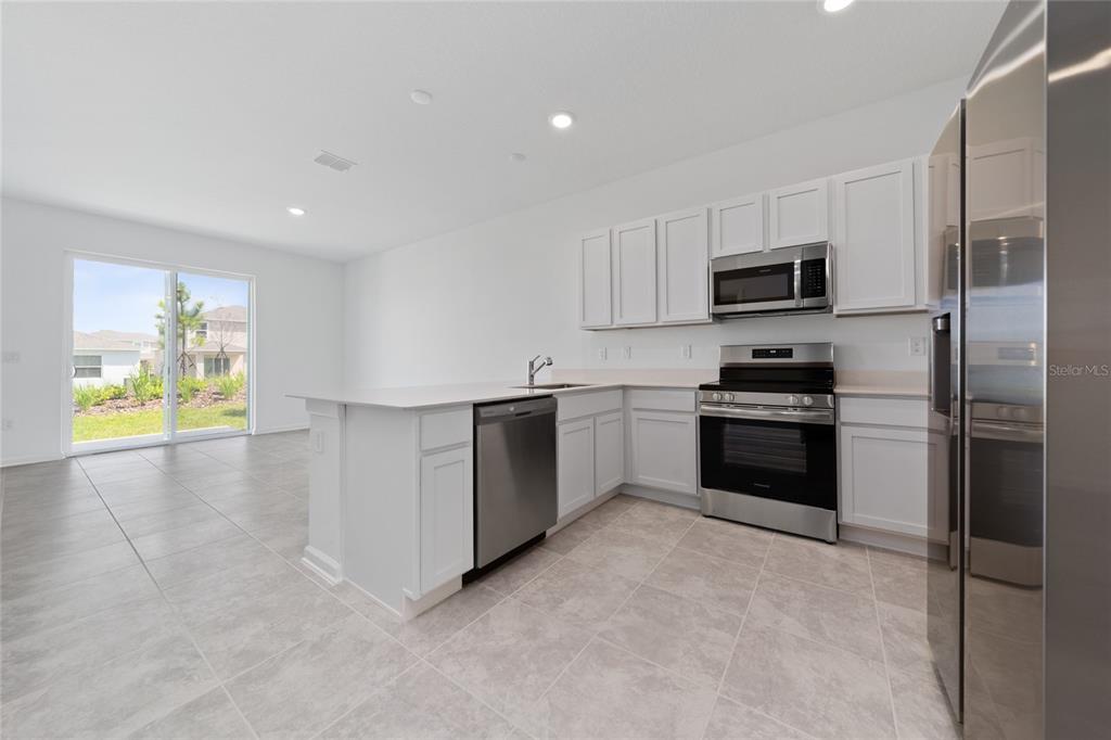 2587 Skyline Loop Kissimmee, FL 34758 - Photo 8 of 27 a kitchen with stainless steel appliances a refrigerator sink and stove