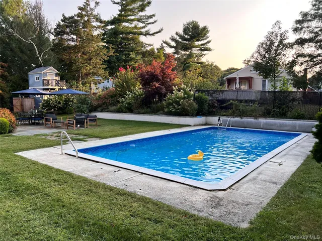 a swimming pool with outdoor seating and yard