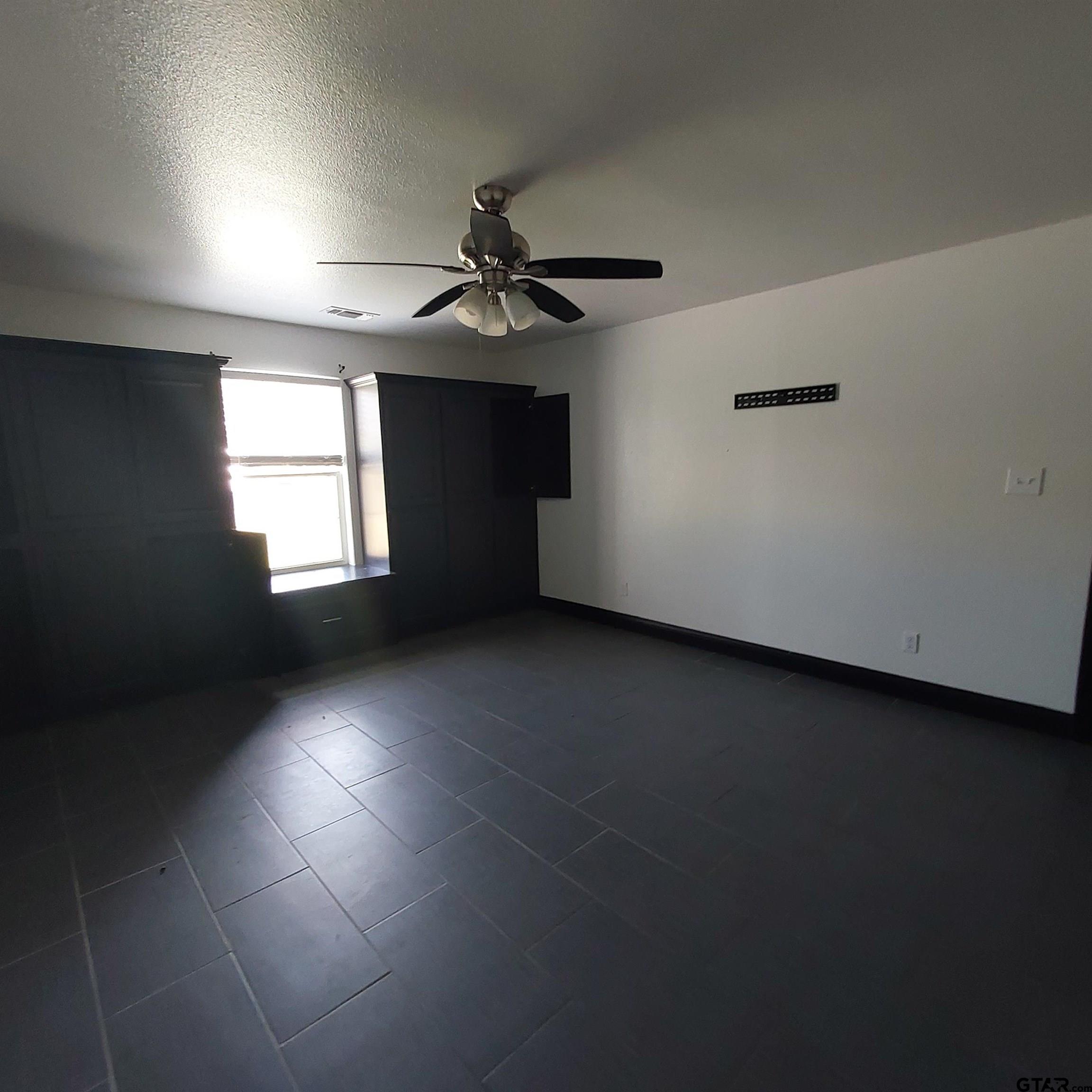 1937 Highway 11 Pittsburg, TX 75686 - Photo 18 of 33 an empty room with windows and fan