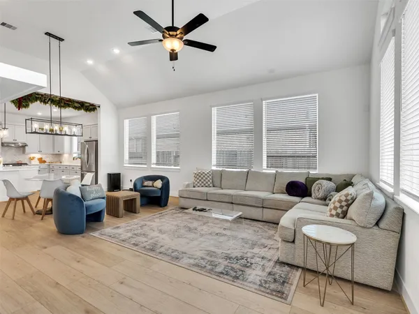 a living room with furniture ceiling fan and a window