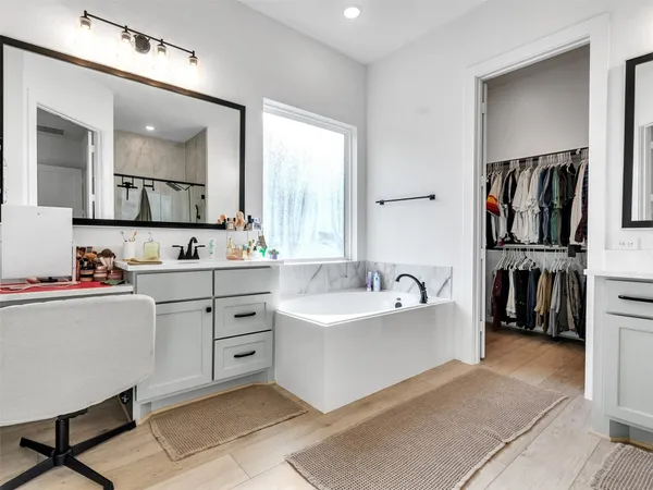 a spacious bathroom with a double vanity sink a mirror and a bathtub