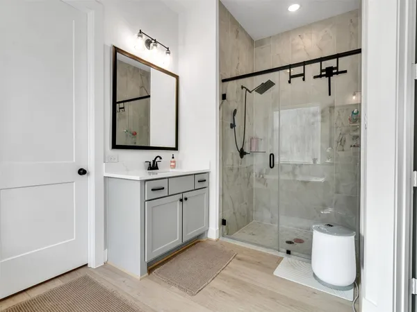 a bathroom with a granite countertop sink mirror toilet and shower