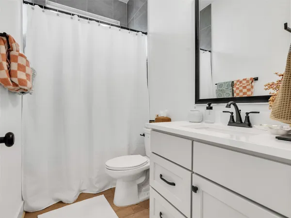 a bathroom with a sink mirror vanity and toilet