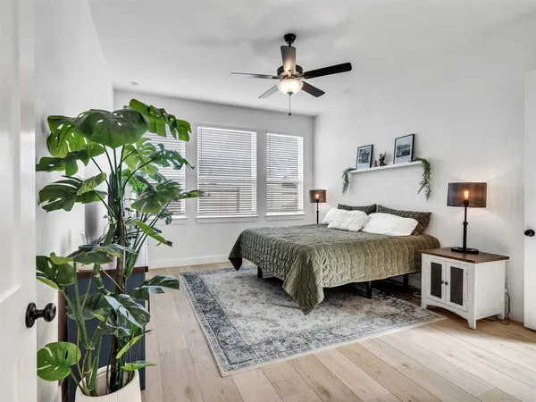 a bedroom with a bed potted plant and a window