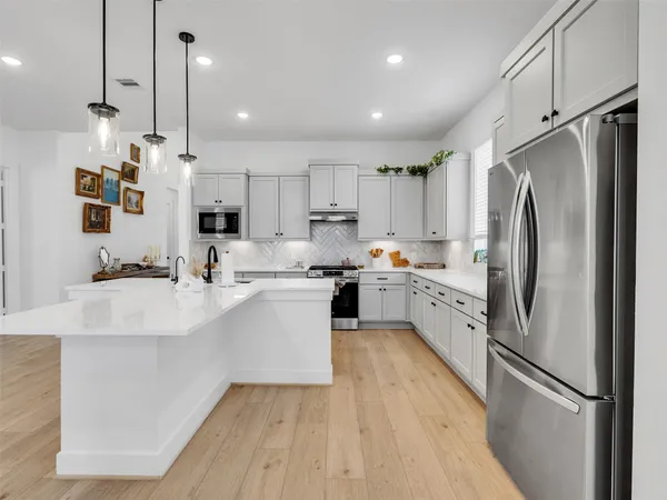 a kitchen with kitchen island white cabinets and stainless steel appliances