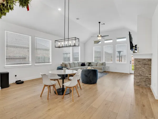 a living room with furniture a dining table and a fireplace