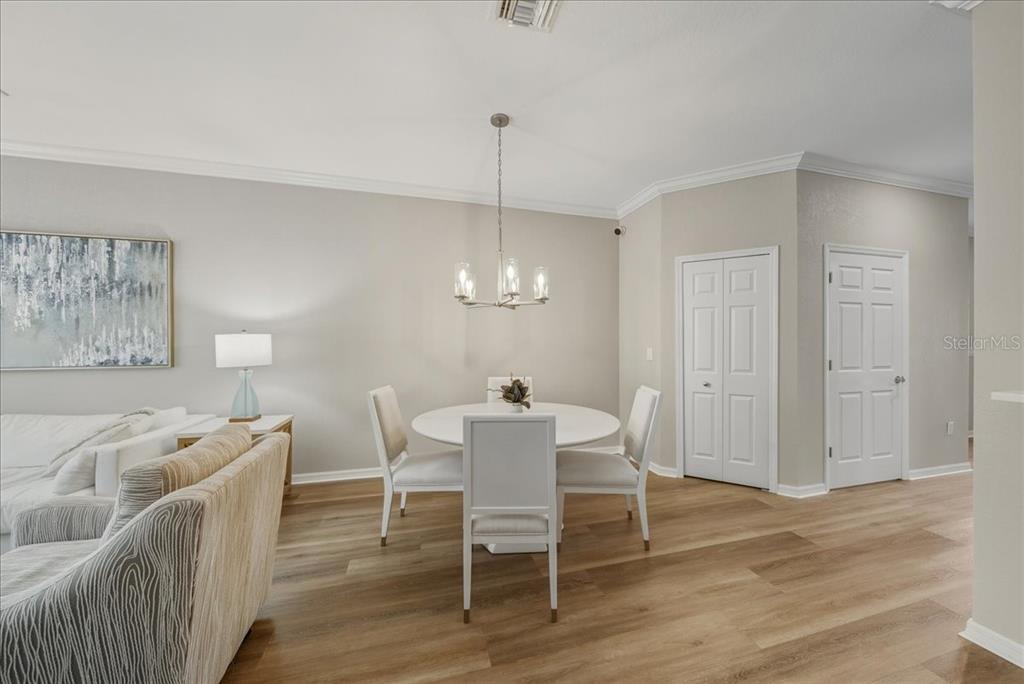 7224 Ketch Place Bradenton, FL 34212 - Photo 14 of 70 a dining room with furniture a chandelier and wooden floor