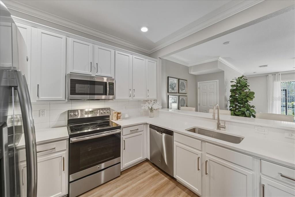 7224 Ketch Place Bradenton, FL 34212 - Photo 8 of 70 a kitchen with white cabinets stainless steel appliances and sink