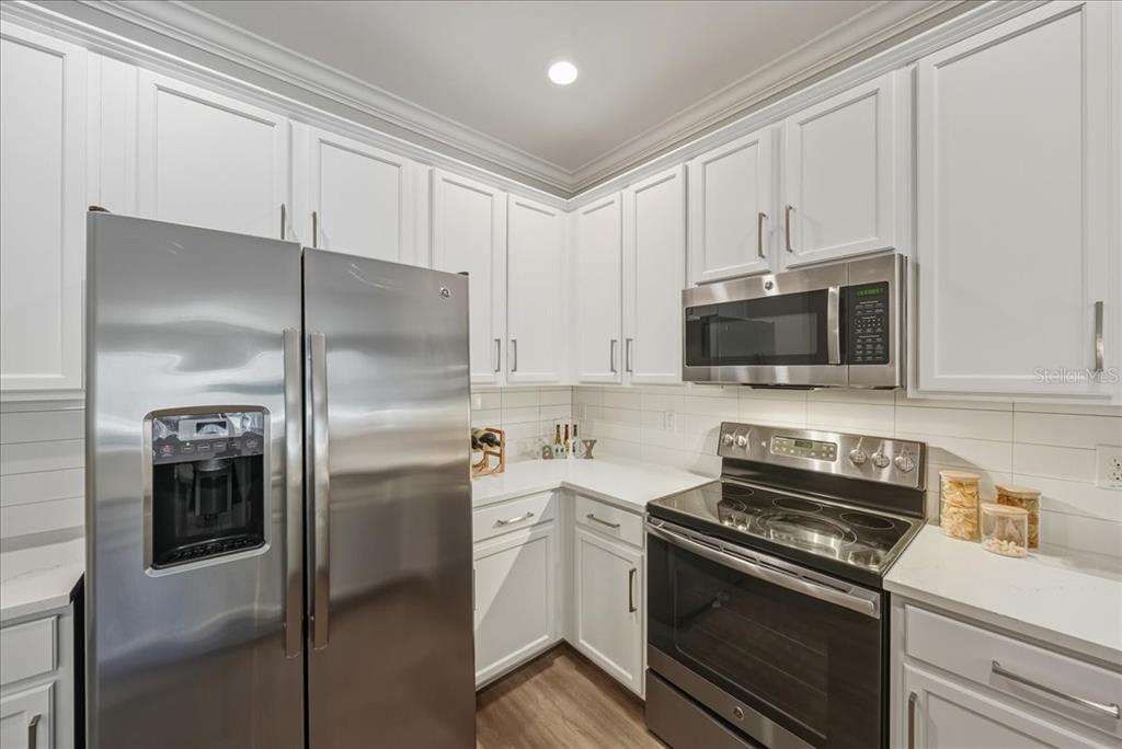 7224 Ketch Place Bradenton, FL 34212 - Photo 10 of 70 a kitchen with stainless steel appliances white cabinets and a stove top oven