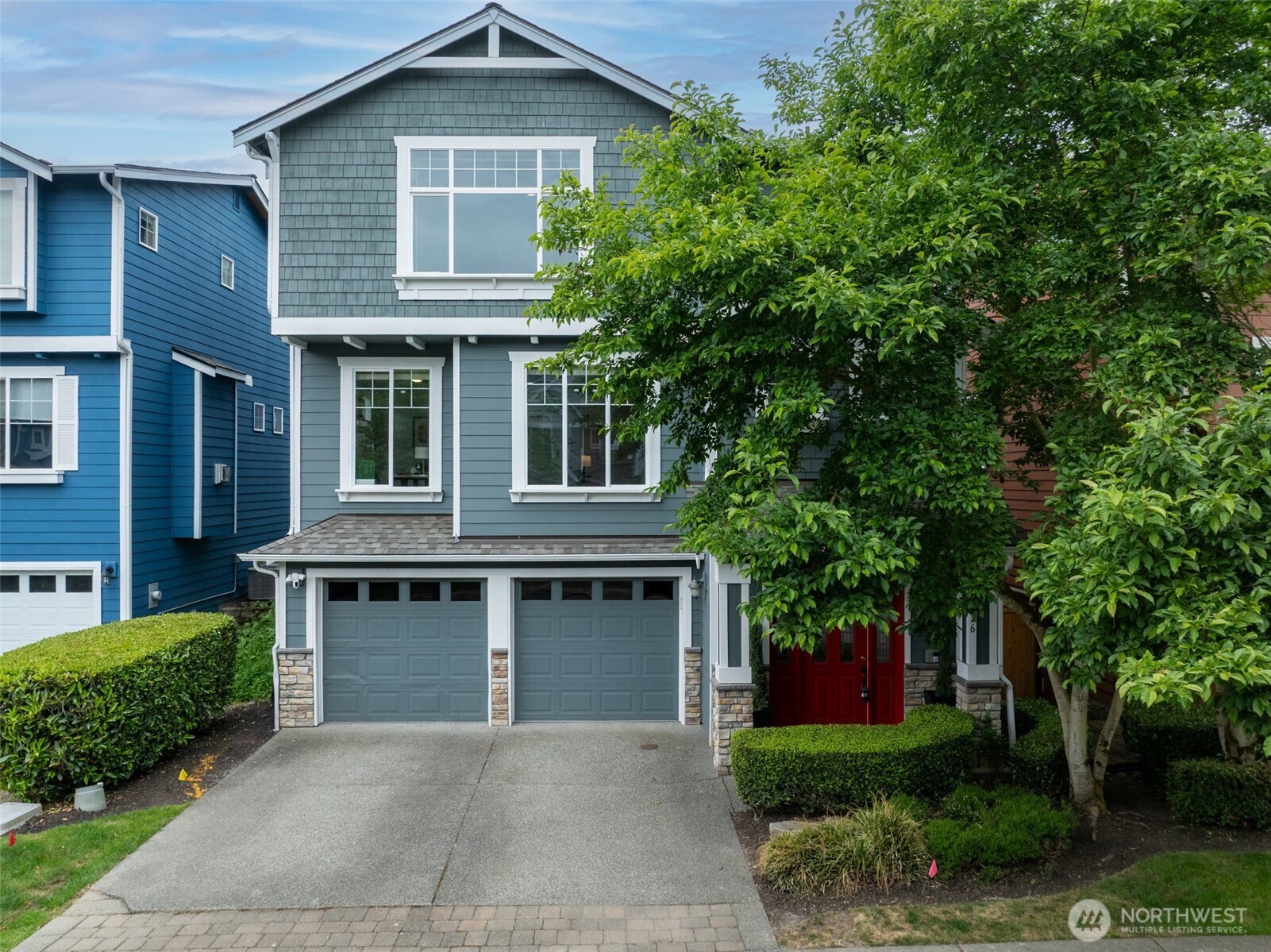 a front view of a house with yard and green space