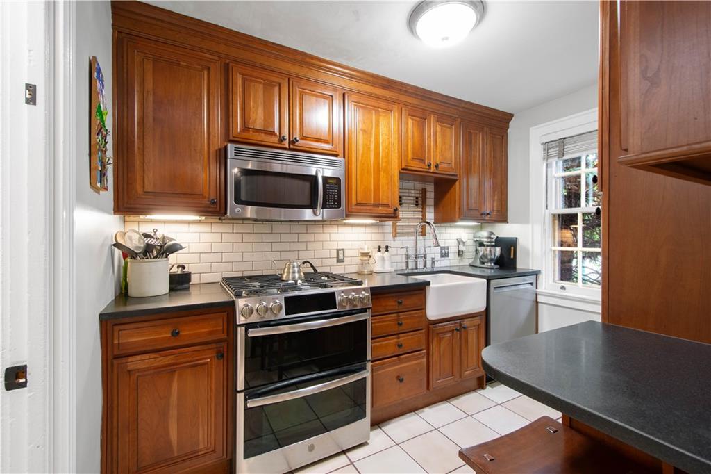 454 Sulgrave Road Pittsburgh, PA 15211 - Photo 12 of 50 a kitchen with granite countertop wooden cabinets stainless steel appliances and a window