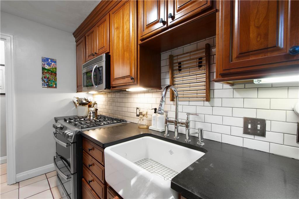 454 Sulgrave Road Pittsburgh, PA 15211 - Photo 15 of 50 a kitchen with stainless steel appliances a sink a stove and cabinets