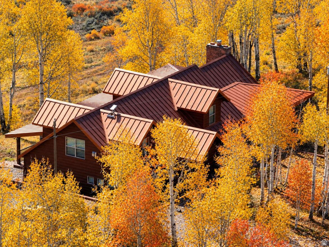 2031 South Quakie Road Koosharem, UT 84744 - Photo 1 of 33 Multi-level residence featuring a brown standing seam metal roof, wood siding, and a prominent brick chimney
