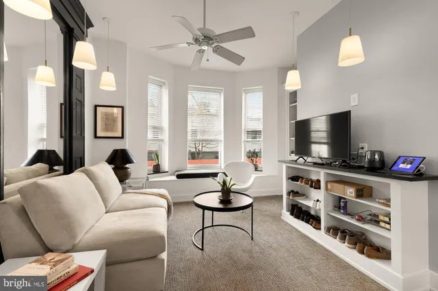 a living room with furniture a flat screen tv and a large window