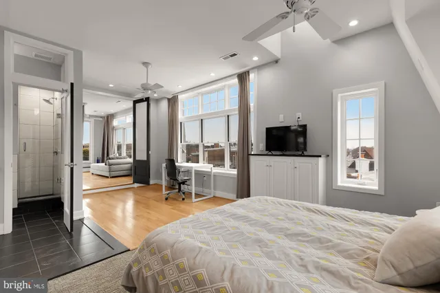 a spacious bedroom with a bed and a flat screen tv