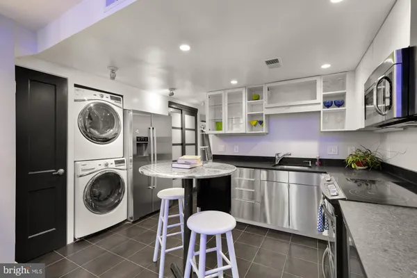 a open kitchen with stainless steel appliances granite countertop a sink and a stove top oven with wooden floor