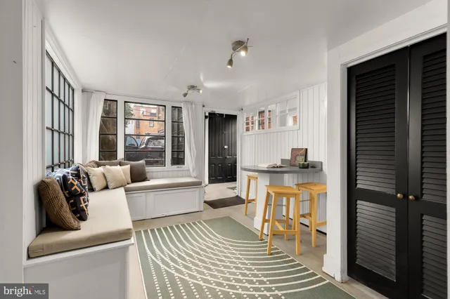 a living room with stainless steel appliances furniture and a kitchen view