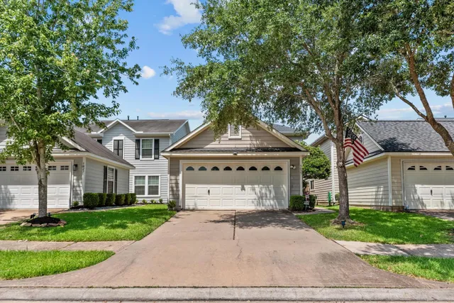 a front view of a house with a yard and a garage
