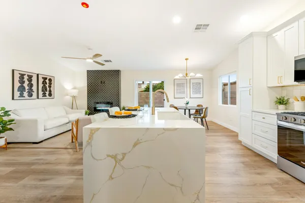 a living room with stainless steel appliances furniture a dining table and chairs