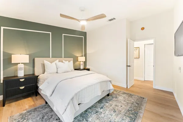 a bedroom with a bed and a painting on the wall