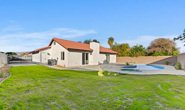 a front view of a house with swimming pool table and chairs