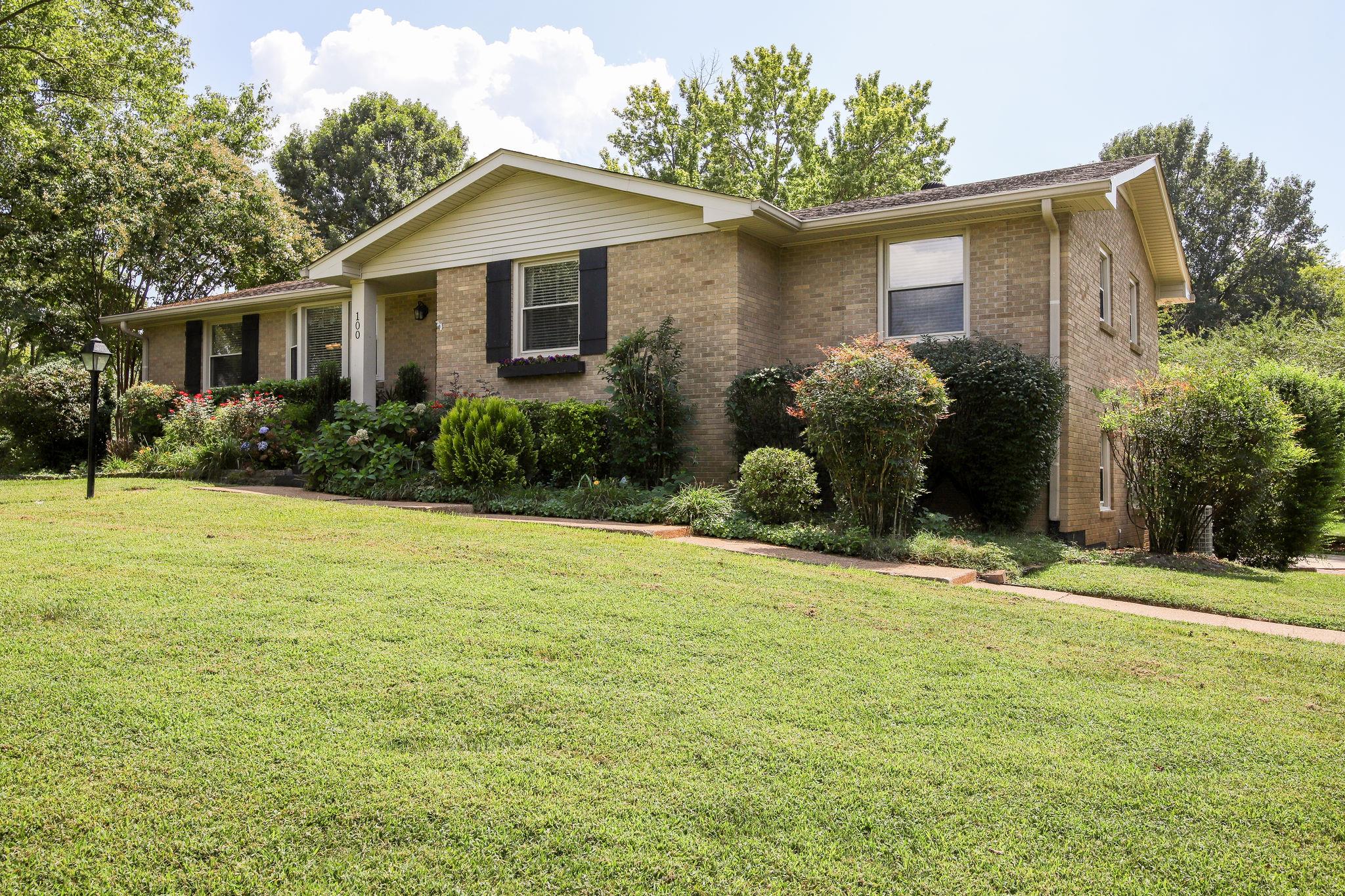 100 Chiroc Road Hendersonville, TN 37075 - Photo 16 of 28 Side view of the home with a curved sidewalk leading to the front porch. LUSH landscaping