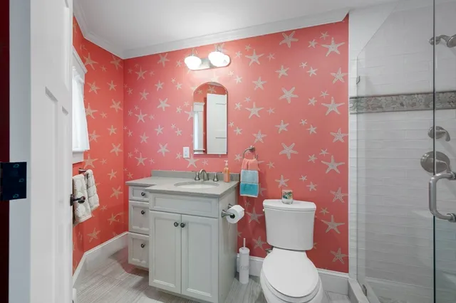 a bathroom with a toilet sink vanity and mirror