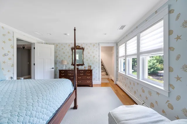 a bedroom with a bed and a large window