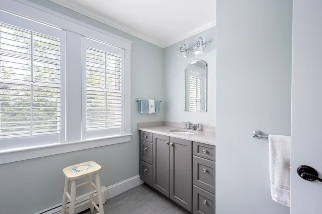 a bathroom with a sink a mirror and a window