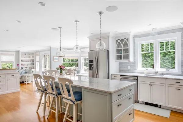 a view of a kitchen with kitchen island granite countertop a table chairs stove and sink