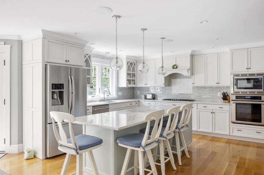 25 Mohawk Way Cohasset, MA 02025 - Photo 10 of 34 a large kitchen with kitchen island granite countertop a stove a sink a oven a dining table and chairs