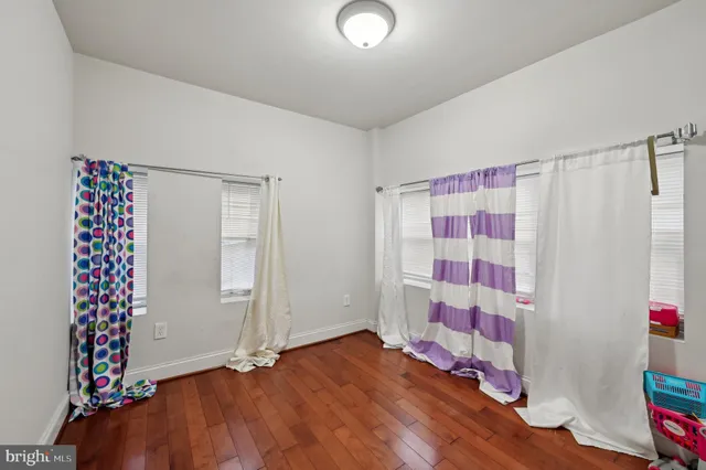 a view of a room with wooden floor and entryway