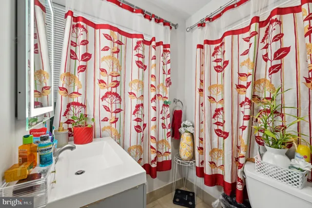 a bathroom with a sink toilet and curtain