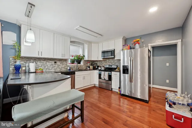 a kitchen with refrigerator cabinets and wooden floor