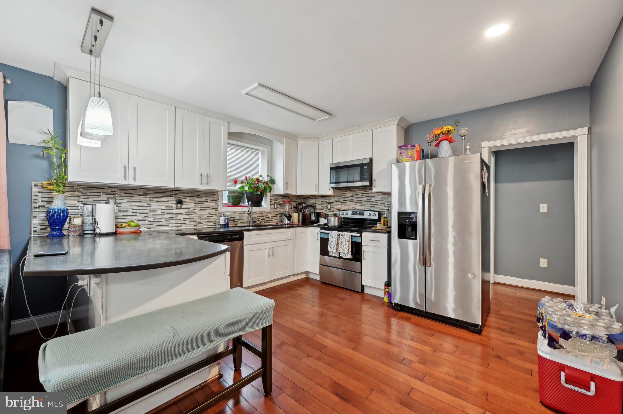 4101 Oak Road Baltimore, MD 21227 - Photo 8 of 25 a kitchen with refrigerator cabinets and wooden floor