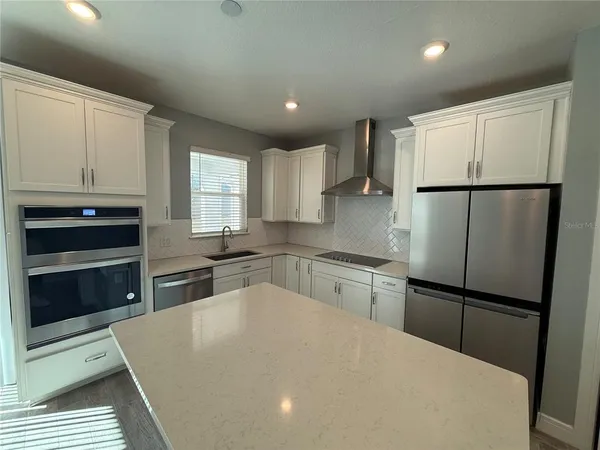 a kitchen with granite countertop a refrigerator stove and microwave