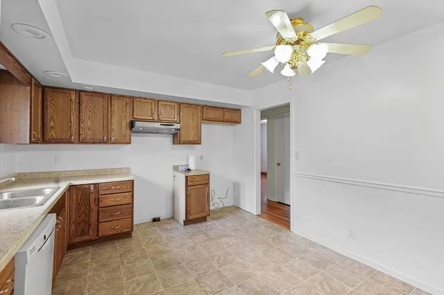 a view of cabinets with stainless steel appliances wooden floor and chandelier