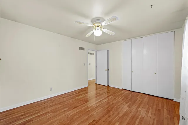 a view of an empty room with wooden floor