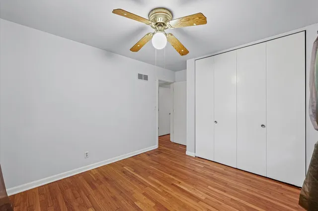 a view of room with wooden floor and ceiling fan