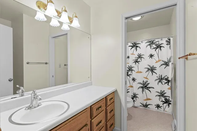 a bathroom with a sink vanity granite tub shower and a mirror