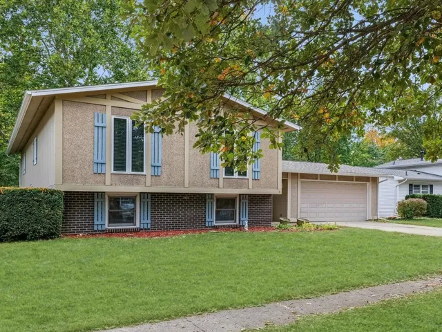 a front view of a house with a garden and yard