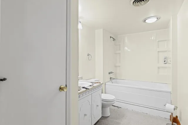 a bathroom with a granite countertop toilet a sink and bathtub