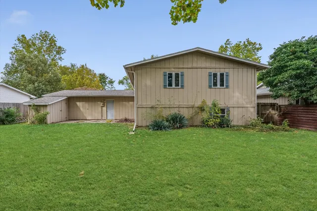 a view of a backyard with plants and large trees
