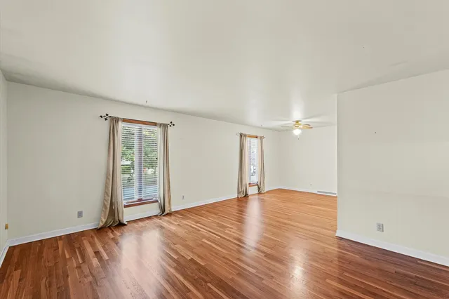 wooden floor in an empty room with a window
