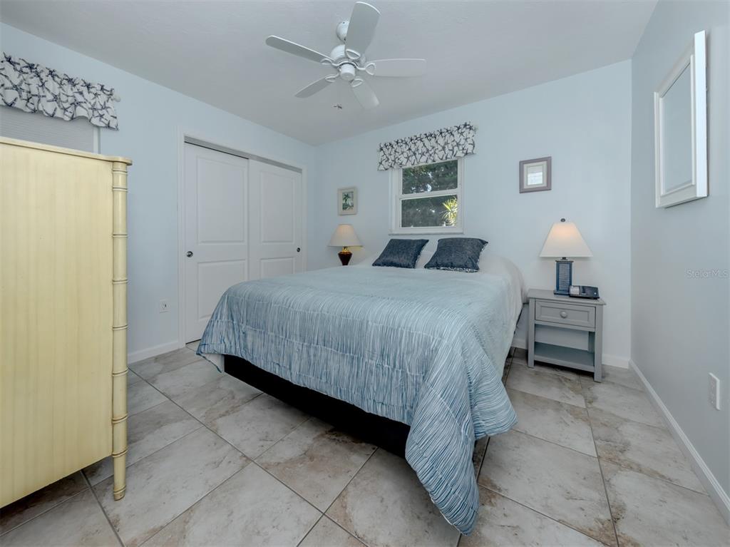 1977 Beach Road, Unit 83 Englewood, FL 34223 - Photo 19 of 48 a bedroom with a bed and a chandelier