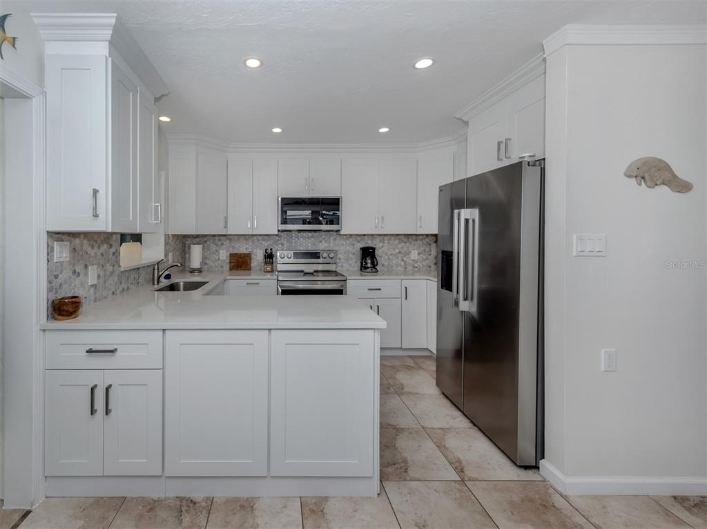 1977 Beach Road, Unit 83 Englewood, FL 34223 - Photo 3 of 48 a kitchen with cabinets and stainless steel appliances
