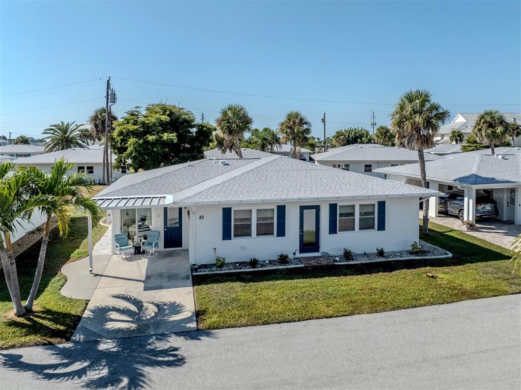 1977 Beach Road, Unit 83 Englewood, FL 34223 - Photo 33 of 48 a front view of a house with a garden and yard