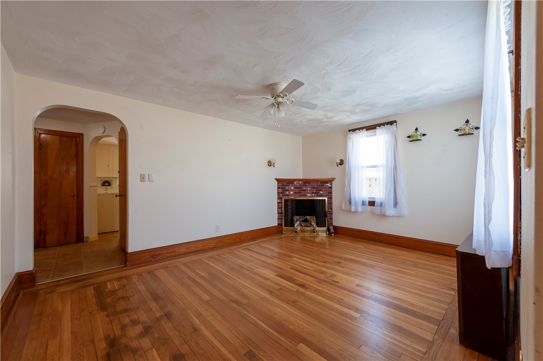 27 Eaton Street Pawtucket, RI 02861 - Photo 3 of 27 Living room in first unit has hardwood floors, coat closet and decorative fireplace.