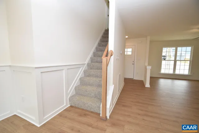 a view of a hallway with wooden floor and staircase