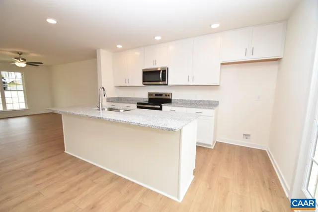 a kitchen with a sink a microwave a stove and refrigerator